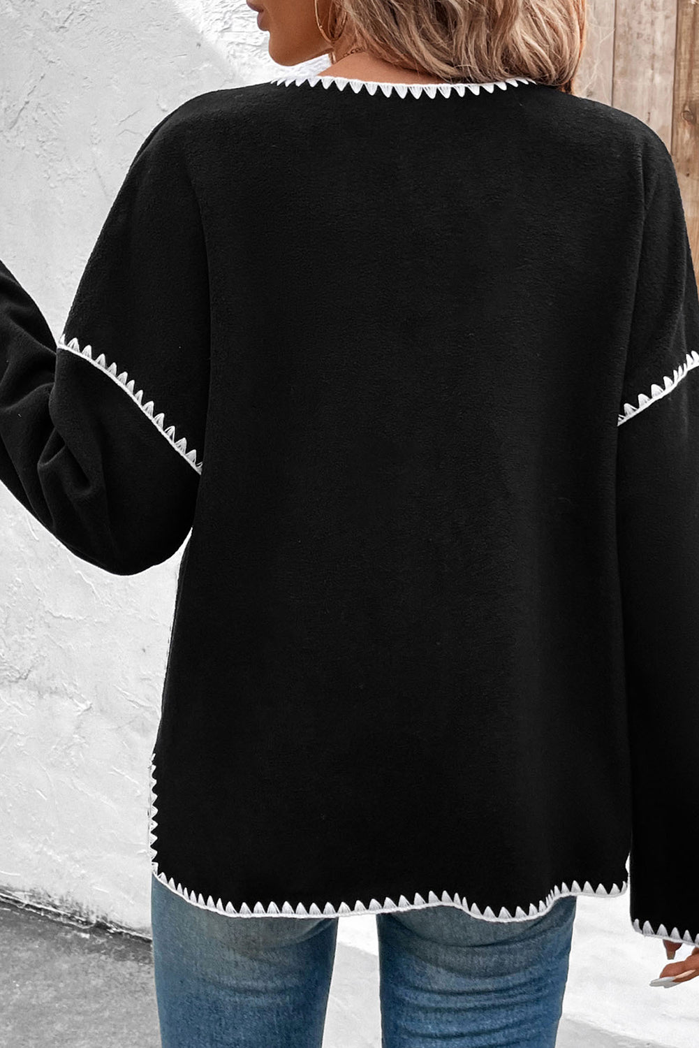 Schwarze, langärmlige Jacke mit Kontrastbesatz und Knopfleiste